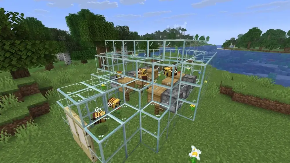 Minecraft bee farm built with glass, beehives, flowers, and bees near a river