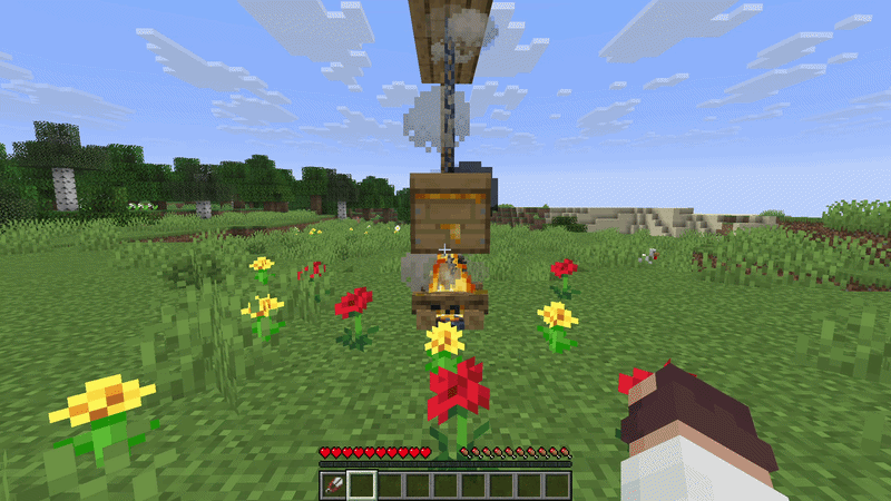 Minecraft beehive above a lit campfire surrounded by flowers